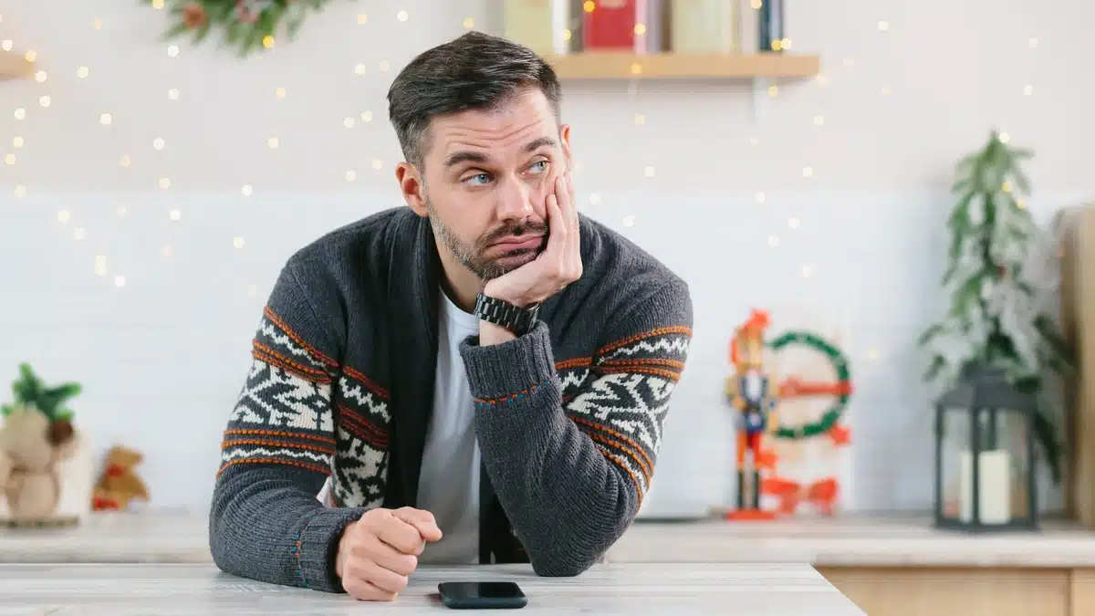 Social Anxiety Can Complicate the Holiday Season - man near his phone away from group