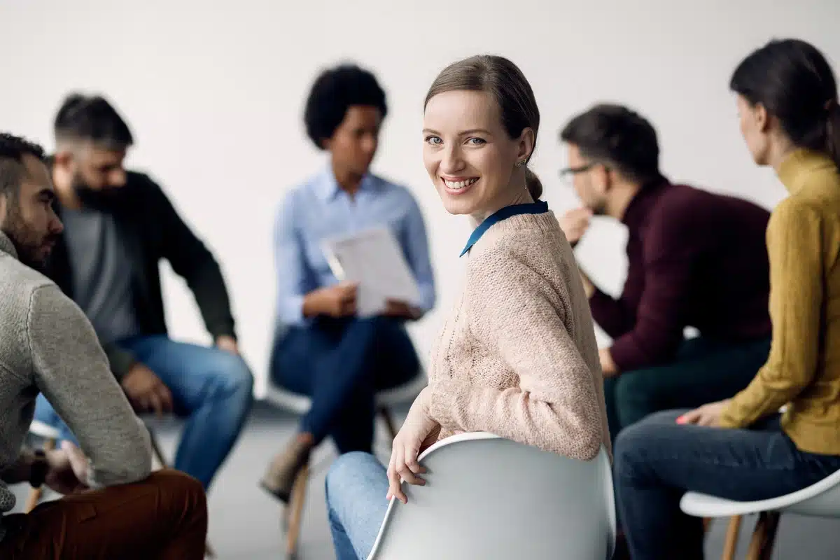 outpatient treatment program - female smiling at group therapy