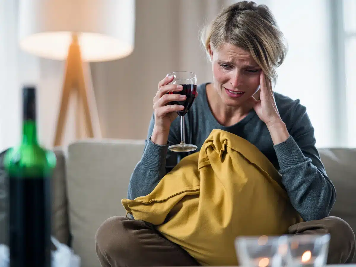 Signs of Alcohol Addiction - depressed female drinking wine