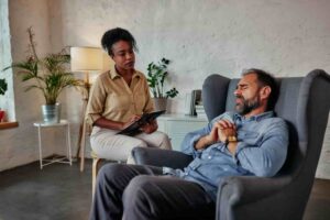 Mental Health Services Man talking with a therapist during an outpatient counseling session