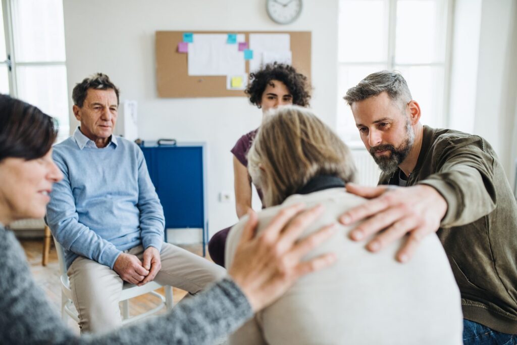 Can You Go to Rehab Without Insurance? Adults supporting each other during an outpatient group therapy session