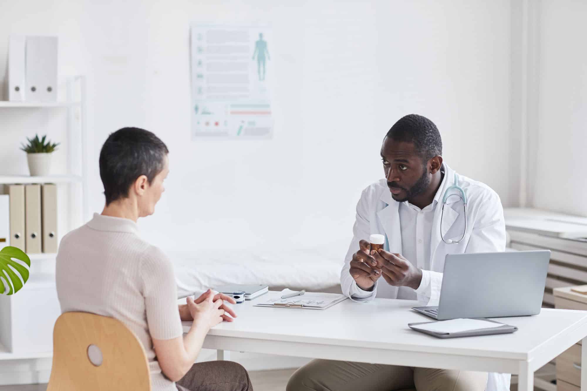 Doctor talking with a patient about her medication and taper plan at a clinic desk